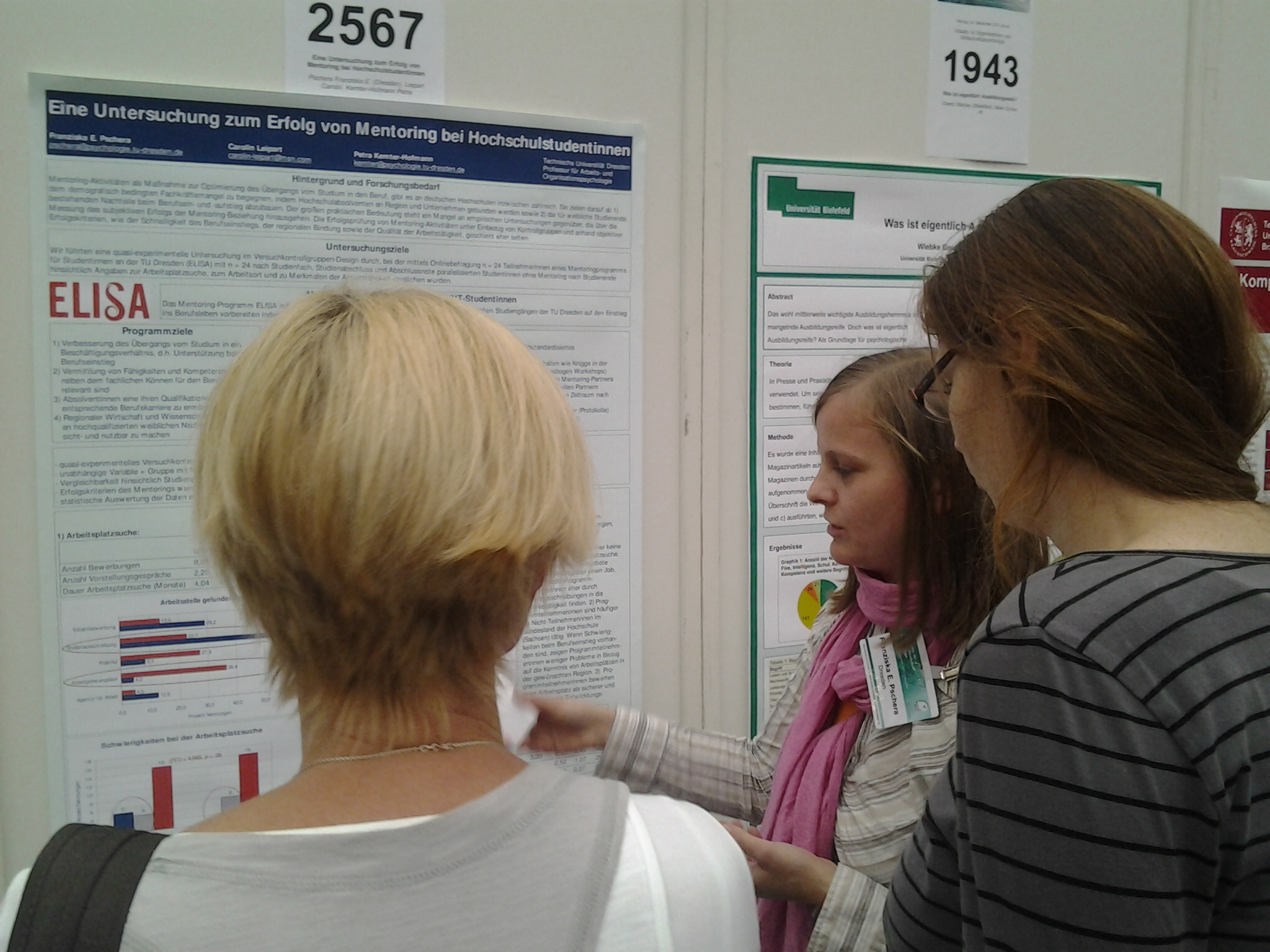 Foto Franziska Pschera im Fachgespräch vor Poster