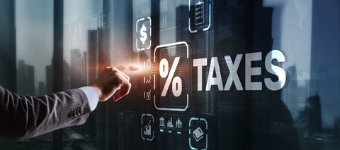 Hand tippt auf Screen, auf dem Taxes steht und andere Symbole abgebildet sind