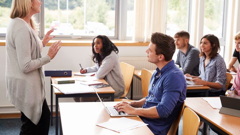 Eine Frau unterrichtet eine Klasse mit älteren Menschen.