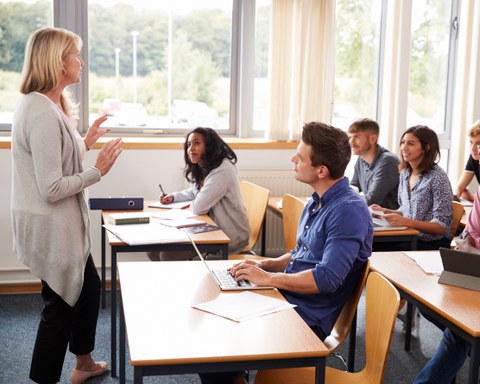 Eine Frau unterrichtet eine Klasse mit älteren Menschen.