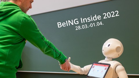 humanoider Roboter gibt Menschen die Hand