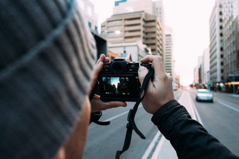 Foto eines Mannes, der mit seiner Kamera ein Foto in einer Großstadt macht.