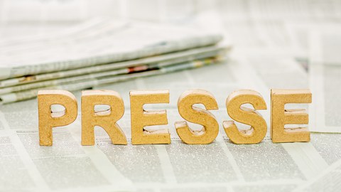 Das Foto zeigt viele Zeitungen. Auf einer Dieser Zeitungen ist das Wort "Presse" mit Hilfe von dreidimensionalen Buchstaben aufgestellt.