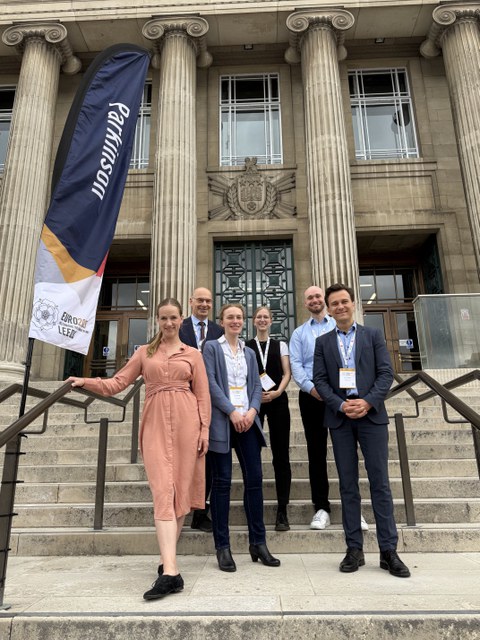 Teilnehmerinnen und Teilnehmer der Konferenz in Leeds stehen auf einer Treppe. Im Hintergrund das Tagungsgebäude.