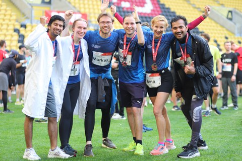 Die Doktorandinnen und Doktoranden mit der geschäftsführerin nach dem Zieleinlauf im Stadion.