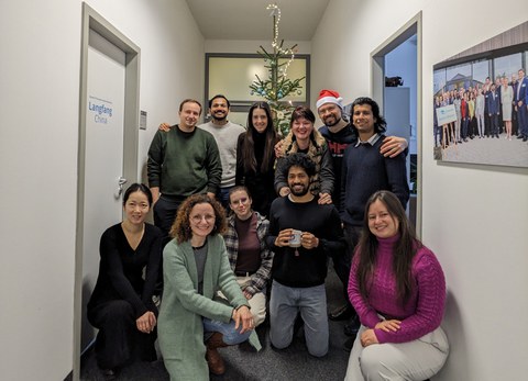 Eine Gruppe Menschen steht vor dem Tannenbaum