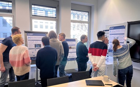 Doktorandinnen und Doktoranden diskutieren die Entwürfe der Cluster Poster