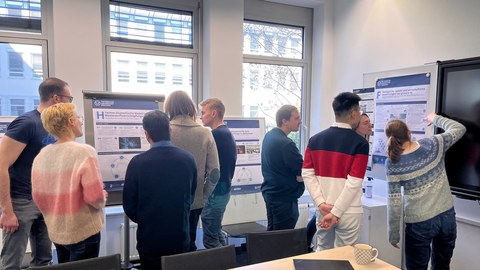 Doktorandinnen und Doktoranden diskutieren die Entwürfe der Cluster Poster