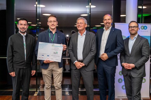 Eine Gruppe von fünf Männern, von denen einer, der Preisträger und Kollegiat Konstantin Schmidt, die Urkunde der Auszeichnung 3. Young Scientists Award in den Händen hält.