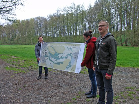 Foto zeigt einen Frühlingsspaziergang durch den Lippepark. Lehrende des Lehrgebietes halten einen Plan zur Veranschaulichung.