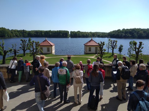 Foto zeigt den Blick vom Schloss zum Fasanenschlösschen in Moritzburg. Der Blick schwift über den Schlossteich in eine Waldachse, die freigelegt ist.