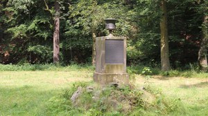 Foto zeigt den Tempel der Freundschaft im Seifersdorfer Tal. Er besteht aus aus einer Säule auf der eine Vase platziert ist. 