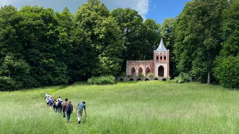 Studierende laufen zur Kapelle im Park von Schloss Buchwald (Polen).