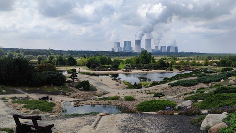Foto mit Blick über den Findlingspark Nochten und dem Kraftwerk im Hintergrund