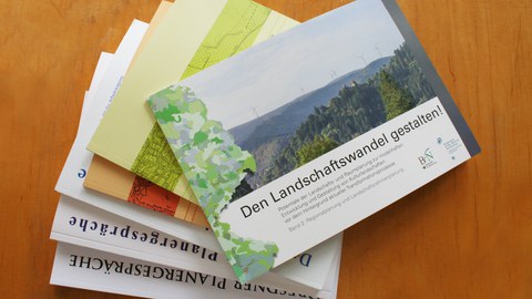 Das Foto zeigt eine Auswahl der erschienen Forschungsarbeiten der Professur für Landschaftsplanung auf einem Tisch liegend.