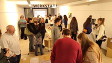 Besucher schauen sich Modele zur Vernissage der Visualisierungswerkstatt an