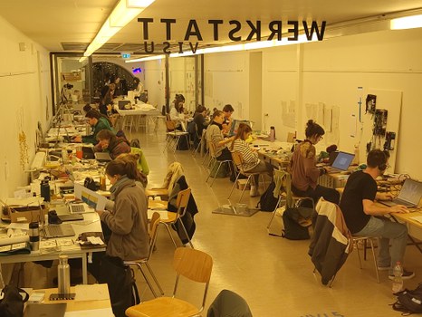 Blick in einen Arbeitsraum mit Studierenden an Tischen