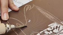Hand mit Linolschnittwerkzeug