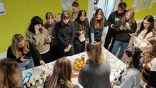 Gruppe von Studierenden stehen um einen gedeckten Tisch