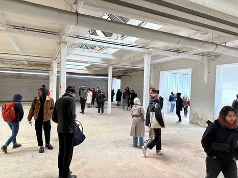studierende in einer leeren Industiehalle von innen