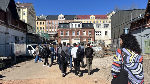 Menschen vor einem Industriegebäude