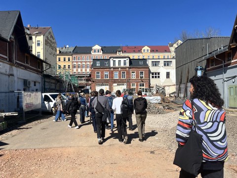 Menschen vor einem Industriegebäude