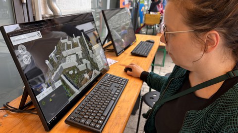 Besucherin vor dem Bildschirm mit dem Co-Design-Tool U_CODE
