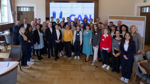 Group picture of U_CAN consortium in front of a screen with the project logo
