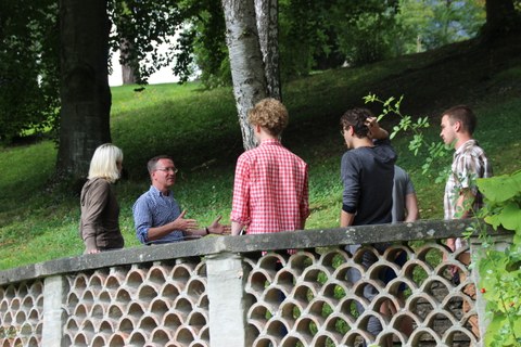 Foto zeigt eine Gruppe von Studenten, die gespannt auf Hernn Professor Marcus Köhlers Erläuterungen zu einem Geländer hören.