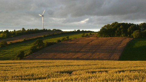 Diese Abbildung zeigt ein Foto einer landwirtschaftlich geprägten Landschaft bei gewittriger Stimmung.