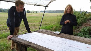 Foto von zwei Personen auf einer Wiese, die an einem Tisch arbeiten