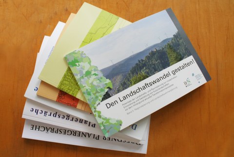 Das Foto zeigt eine Auswahl der erschienen Forschungsarbeiten der Professur für Landschaftsplanung auf einem Tisch liegend.