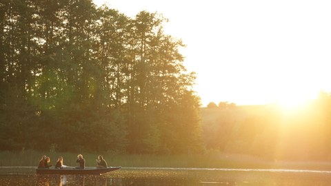 Ruderboot auf einem See vor dem Sonnenuntergang