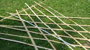 Foto von Bambusstangen im Gras für Gerüstbau 