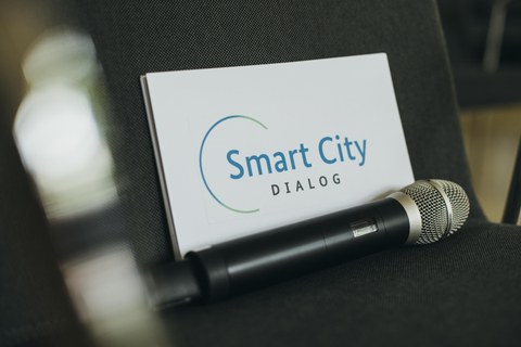 Logo Smart City Dialog, darunter ein Mikrophon