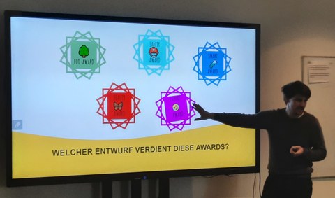 Andreas Wilde erklärt die Awards, mit denen Schüler:innen die Klassenentwürfe ausgezeichnet haben 