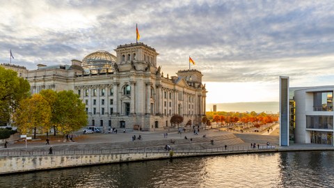 Herbstimpressionen vom Reichstagsgebäude am Spreeufer im Parlamentsviertel in der Abenddämmerung. Rechts ist das Paul-Löbe-Haus zu sehen. 