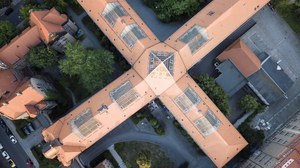 Das Foto zeigt eine Luftaufnahme des Hülsse-Baus der TU Dresden. Das Foto wurde aus der Vogelperspektive aufgenommen. Von oben hat es die Form eines Kreuzes.