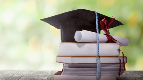 Graduation Hut mit Grad Papier auf einem Stapel Bücher