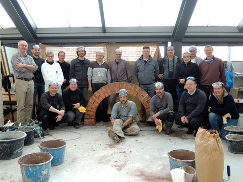Gruppenbild der Workshopteilnehmer vor dem fertiggestellten Bogen