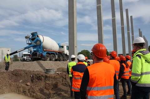 Studenten auf einer Goldbeck Baustelle vor Betonfertigteilstützen