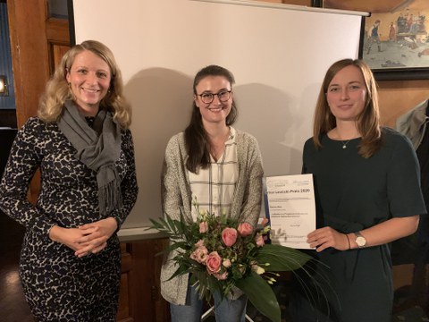 Die Preisträgerin des Lewicki-Preises (Frau Sabrina May) mit Blumenstrauß und Urkunde, links davon Frau Dr. Anne Harzdorf, rechts davon Frau Romy Adam.