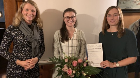 Die Preisträgerin des Lewicki-Preises (Frau Sabrina May) mit Blumenstrauß und Urkunde, links davon Frau Dr. Anne Harzdorf, rechts davon Frau Romy Adam.