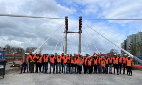 Gruppenfoto aller Teilnehmer an der Frühjahrsexkursion 2023 im Hamburger Hafen vor einer Brücke