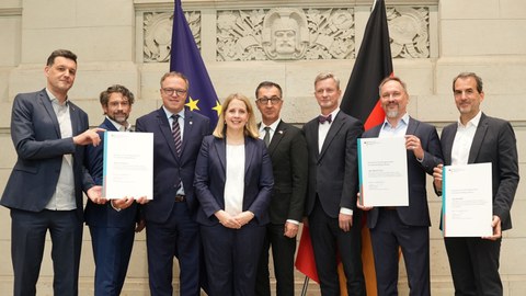 Federal Minister Verena Hubertz, along with, among others, Minister Presidents Cem Özdemir and Mario Vogt, as well as representatives of research institutions, in the foyer of the Bundesrat