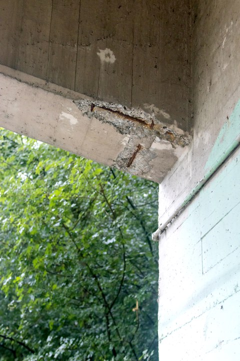 Concrete spalling as typical damage to a concrete bridge 