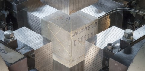 Concrete cube with embedded fiber optic sensor surronded by load introduction brushes