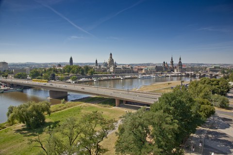 Foto zeigt die Carolabrücke in Dresden von erhöhter Position. Im Hintergrund ist die Stadtsilhouette erkennbar.