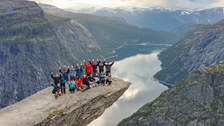 Foto zeigt die Exkursionsgruppe wagemutig auf dem Trolltunga-Felsen