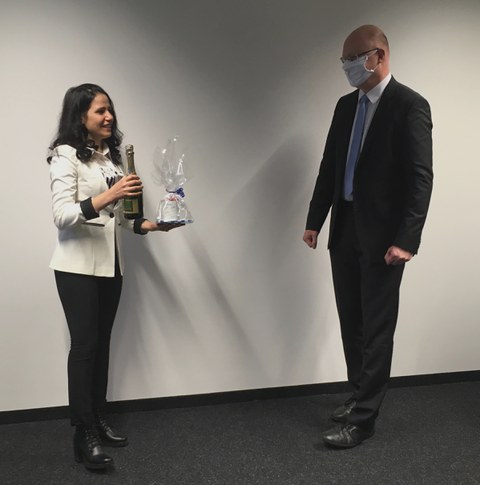 Foto Fr. Hosseini bekommt von Prof. Löhnert eine Sektflasche und ein Geschenk der Arbeitsgruppe überreicht